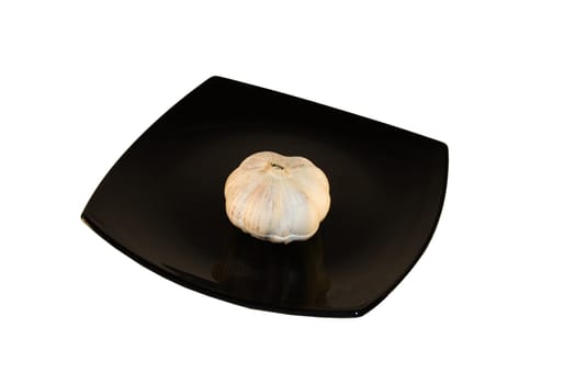 Black glass square plate with garlic isolated over white