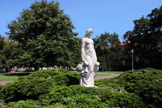 White statue of woman in the city park