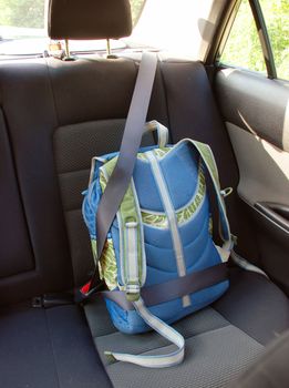 children schoolbag fasten by belt in car