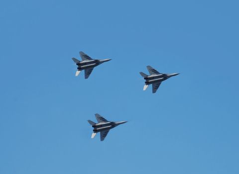 military fast gray planes MIG 29 over blue sky