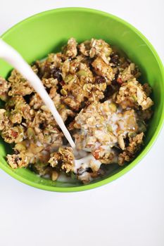 pouring milk on granola cereal