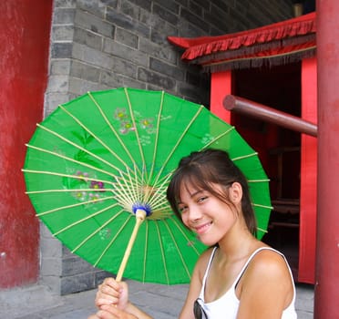 Beautiful girl with traditional chinese green parasol.