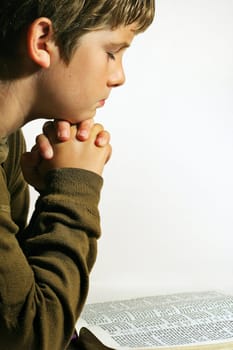 shot of a Young boy praying vertical on white