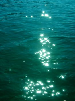 sun reflection on green sea water abstract