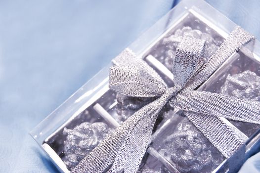 silver gift box over light blue fabric