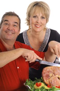 happy couple carving a ham