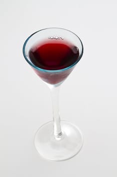 Small glass of red wine against a white background