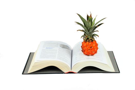 open book and pine apple isolated over white