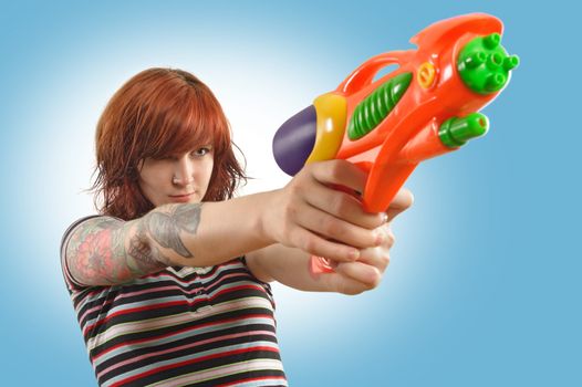 Photo of a beautiful redhead about to shoot a water gun.