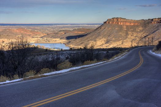 mountain highway at foothills of northern Colorado with a view at Flatiron Reservoir and city of Loveland, early winter