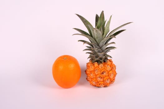 small pine apple and orange over white background