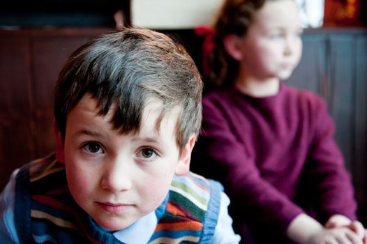 boy in sweater, girl behind in violet dress.