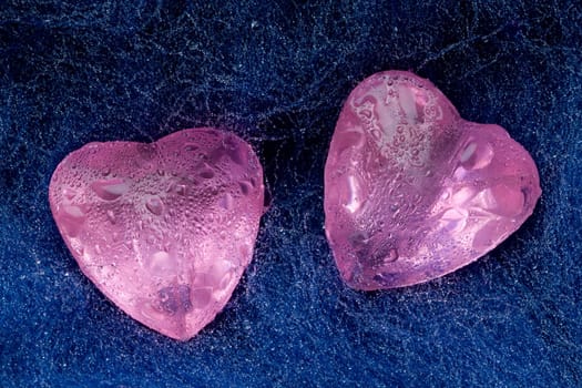 Two pink crystal hearts lie on the wool