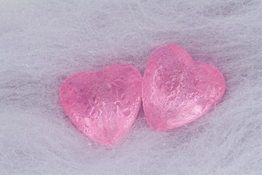 Two pink crystal hearts lie on the wool