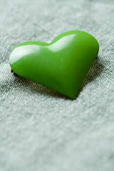 The green iron heart on the cloth background