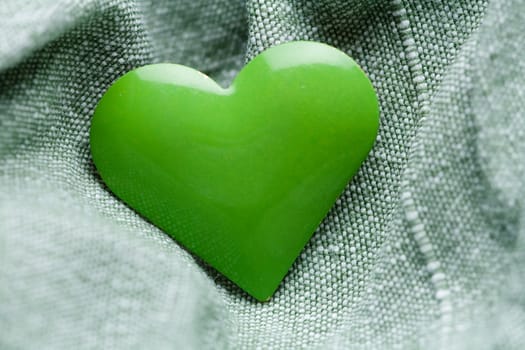 The green iron heart on the cloth background