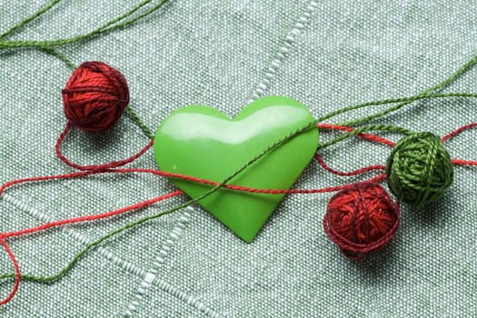 The green iron heart with the three clews on the cloth background