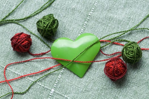 The green iron heart with the four clews on the cloth background