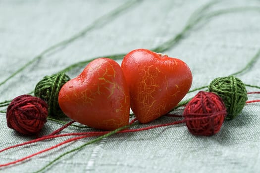 Two red hearts with the four clews on the cloth background