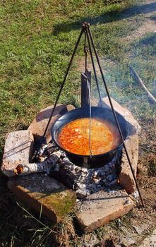 orange fish soup in copper boiling outdoor