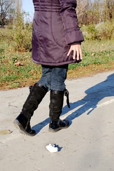 girl throwing garbage on road in autumn park outdoor