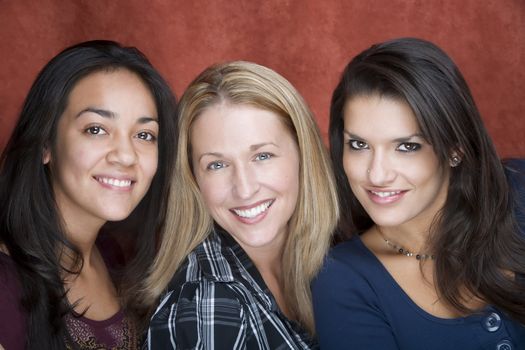 Three pretty women smiling in a studio setting