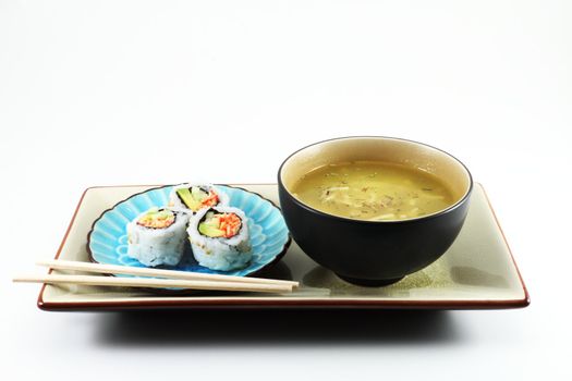 Fresh sushi served with a bowl of soup and chopsticks.