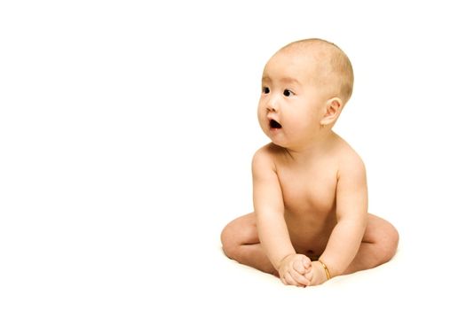 A naked 6 months old baby is sitting alone