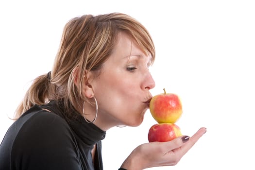 Pretty blond girl on white background kissing apples