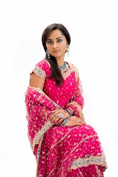 Beautiful Bangali bride in colorful dress sitting, isolated