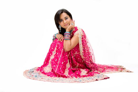 Beautiful Bangali bride in colorful dress sitting, isolated