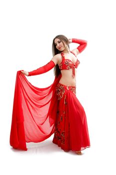 Beautiful belly dancer in red outfit holding veil, isolated