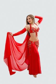 Beautiful belly dancer in red outfit holding veil, isolated