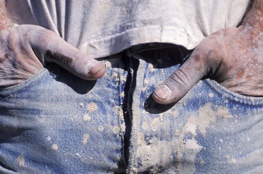 Close-up of worker's hands in pockets
