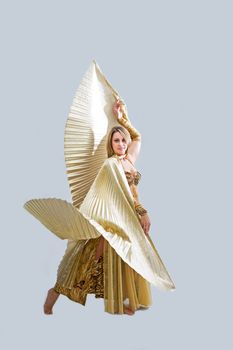 Beautiful belly dancer in gold outfit with wings, isolated