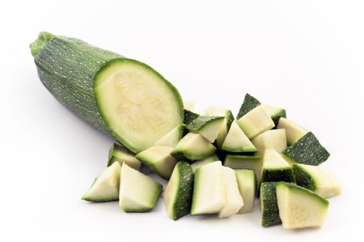 half zucchini and some pieces of it isolated on white