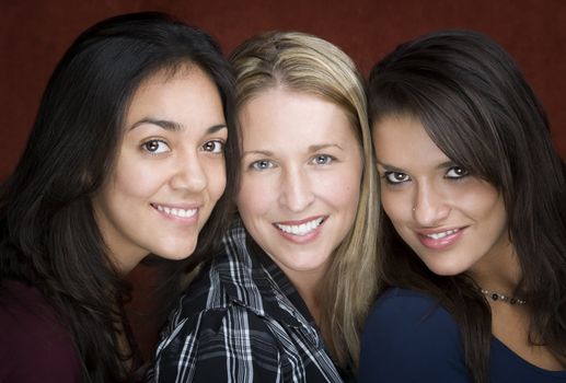 Three smiling young women in a studio setting