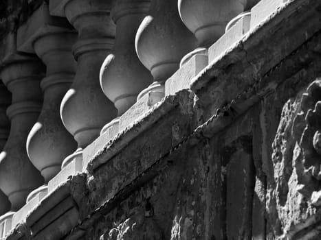 Detail in monochrome of stone balustrades on a balcony in Malta