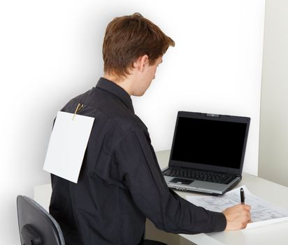 A man very busy with work. On the back is attached a piece of paper.