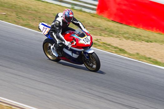 Motor racer driving on race-course passing by at high speed