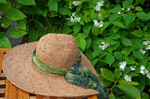 A straw hat on a table in a garden