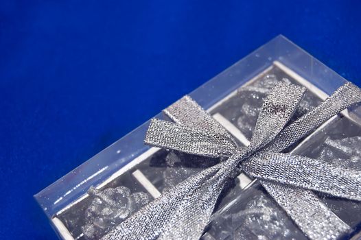 Silver gift box over blue satin fabric