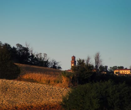 Landscape of a hill and a little town, under blue sky