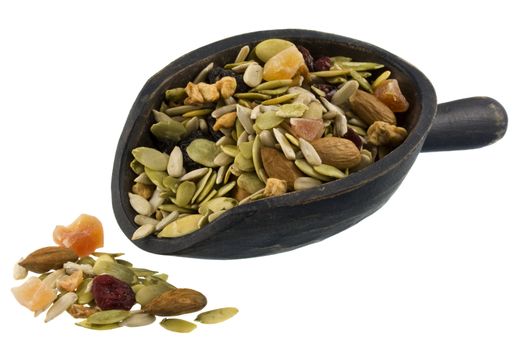 trail mix with pumpkin, sunflowers seeds, almonds, dried papaya,  cranberries, raisins and apples on a rustic wooden scoop isolated on white