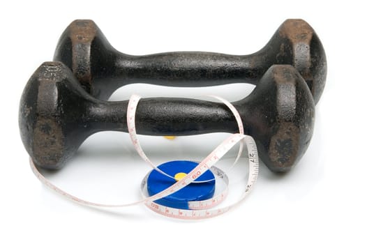 Old iron dumbbells and tape measure, white background
