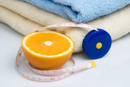 Pile of towels, tape measure and half of orange