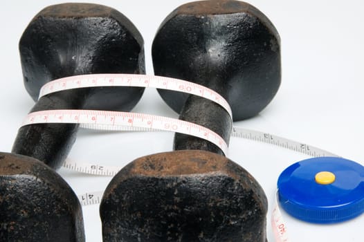 Old iron dumbbells and tape measure, white background