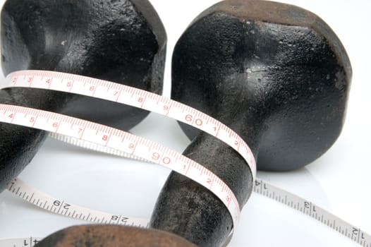 Old iron dumbbells and tape measure, white background