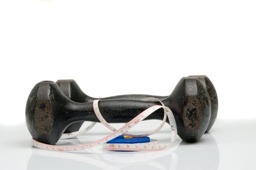 Old iron dumbbells and tape measure, white background