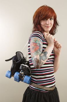 Photograph of a roller derby girl holding her skates by the laces.